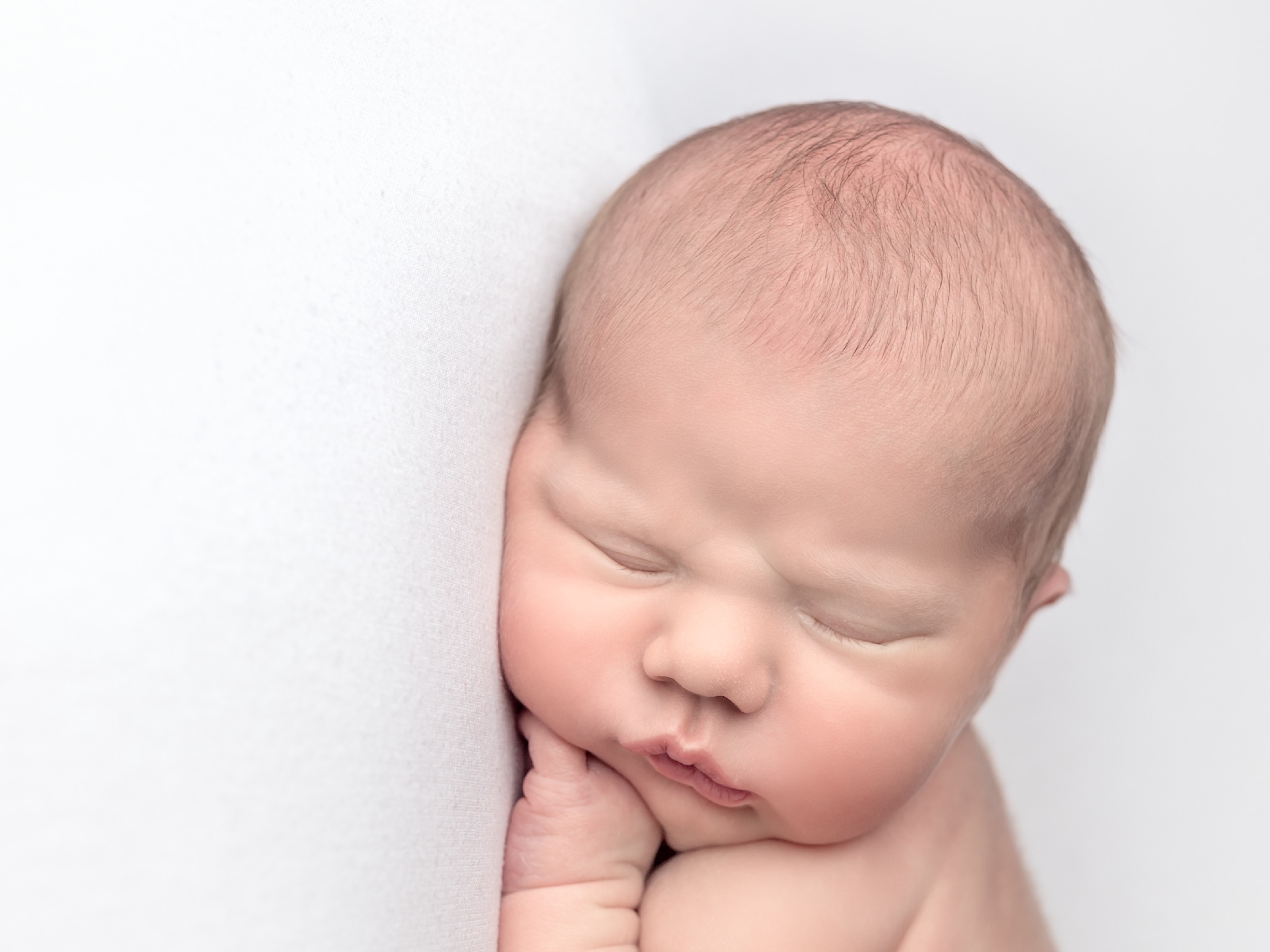 Close up of a peacefully sleeping newborn baby at a newborn baby photoshoot at Fairy Nuff Photography, Nottingham. 