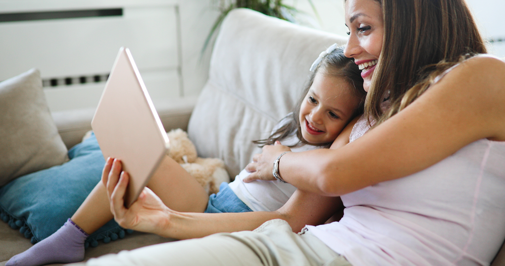 Mum and Daughter with a tablet smiling