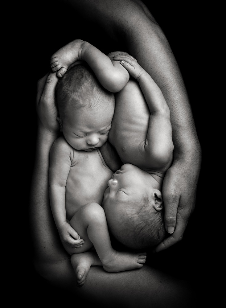 Black and white image of twins posed together