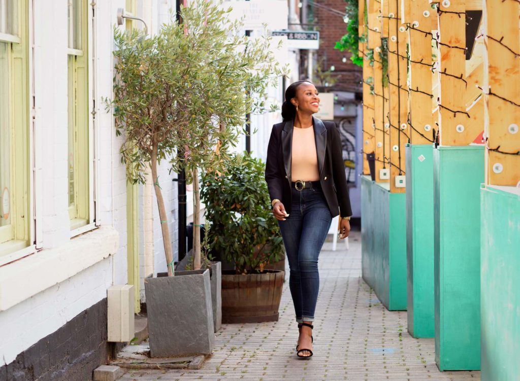Business woman walking through a city centre looking relaxed and happy at a marketing photo shoot