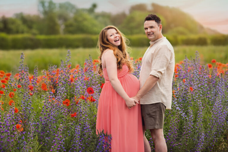 Outdoor maternity photoshoot of a couple in wildflowers looking at camera at Fairy Nuff Photography, Nottingham
