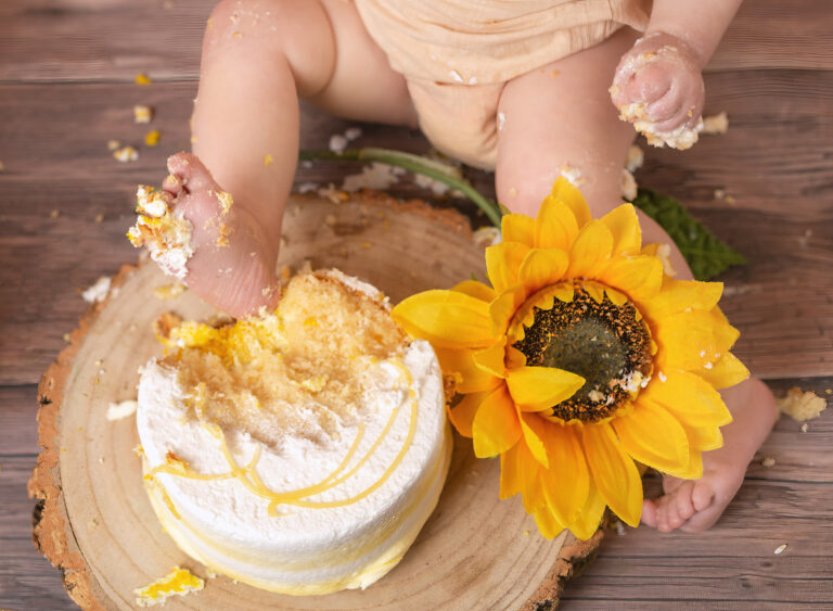 one year old and their cake smashing with their feet - 1st birthday and cake smash photoshoot with Fairy Nuff Photography, Nottingham